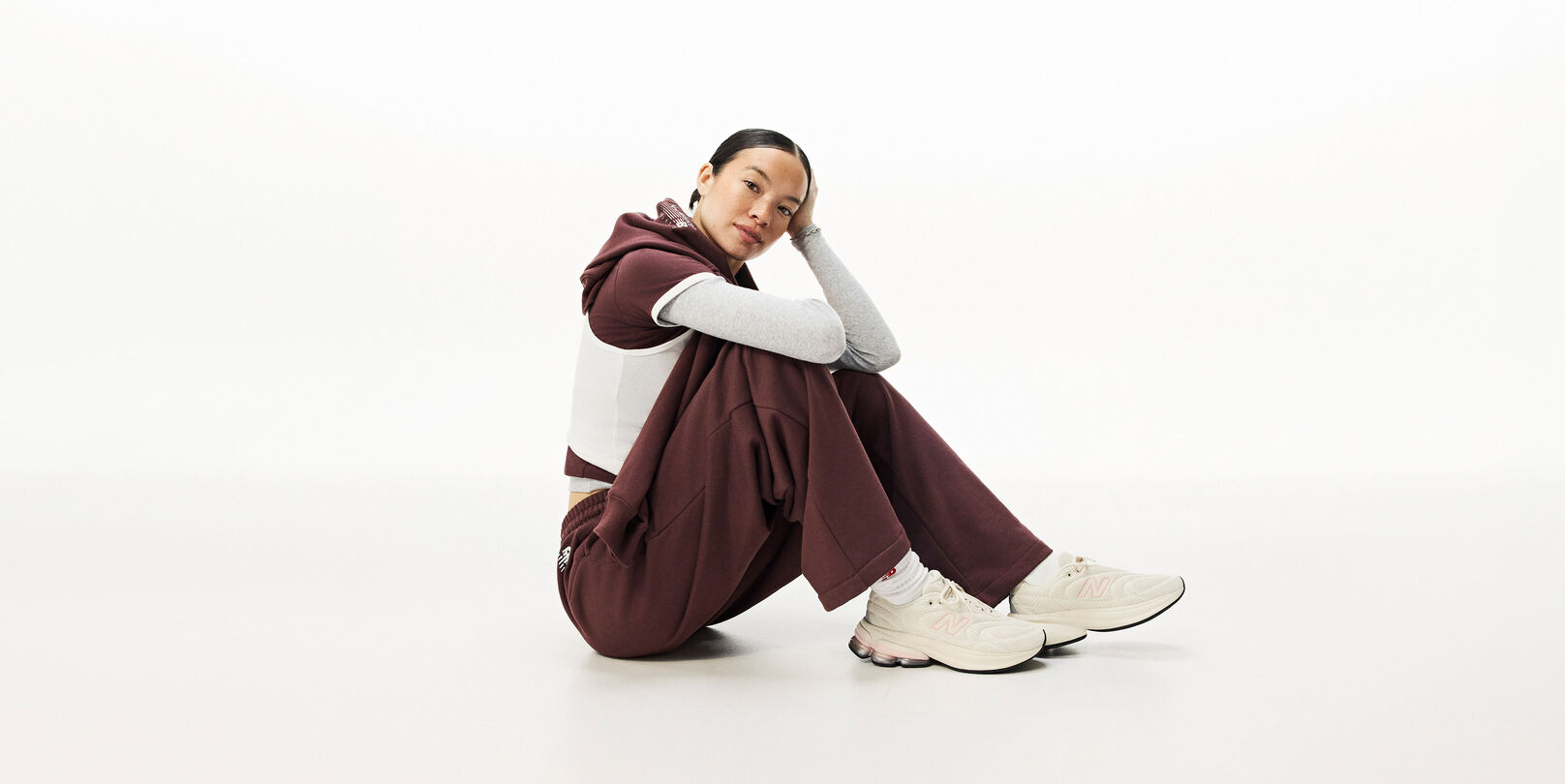 A woman sitting down on the ground with her head resting on her hand